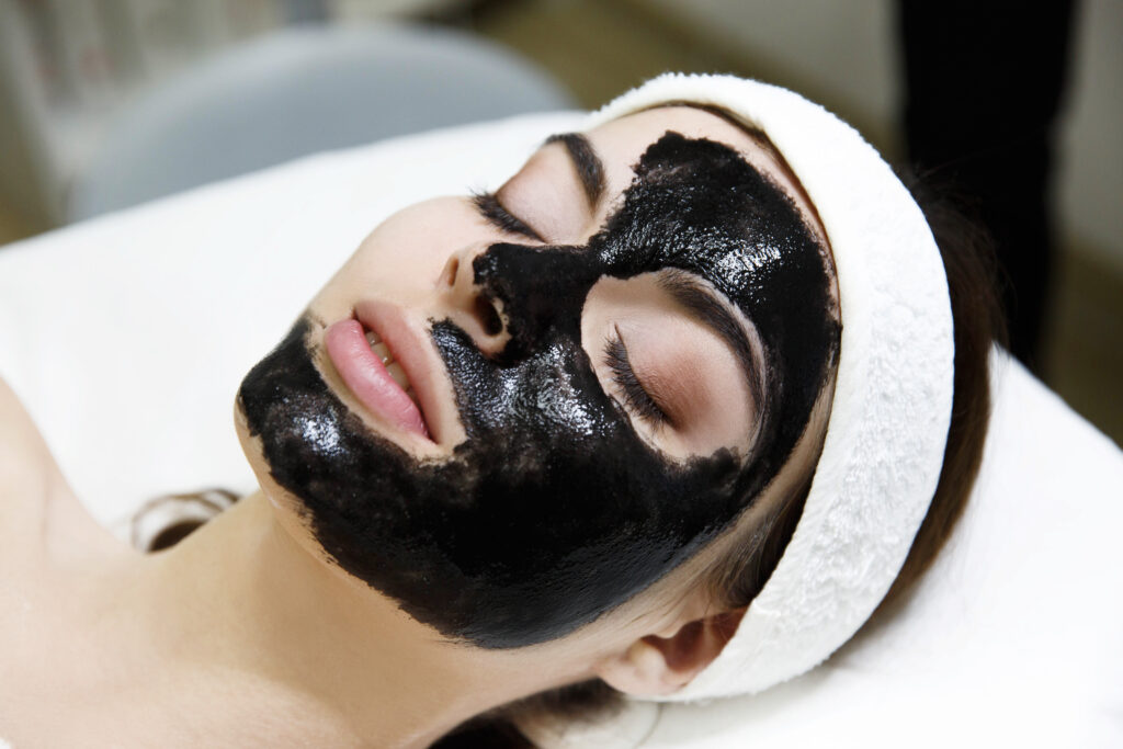 girl with black mask lies table spa saloon